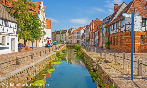 Blick auf mittelalterliche Gasse in Wismars Altstadt mit mittigem Wassergraben