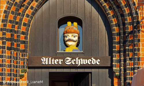 Blick auf Holzfigur, ein sogenannter "Schwedenkopf" in alter Gewölbetür mit Aufschrift "Alter Schwede"